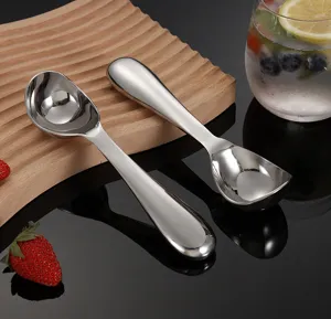Stainless steel ice cream scoop detail, mirror polished metal fruit ball digger spoon close up.