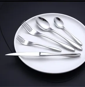 Dettaglio set di posate in acciaio inossidabile con superficie lucida, coltello, forchetta.