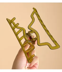 Vista dettagliata di un'elegante molletta per capelli geometrica verde oliva per styling.