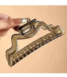 Primo piano di una grande molletta per capelli traforata da 13 cm in marrone traslucido con design.
