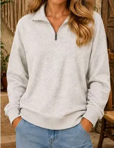 Detailed view of women's half-zip long sleeve sweatshirt in light gray casual style.