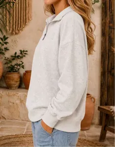 Detail view of women's half-zip long sleeve sweatshirt in light grey, casual loose drop-shoulder fit.