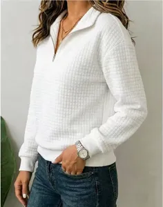 Detail of white waffle knit 1/4 zip sweatshirt showing textured fabric and stylish collar zipper.