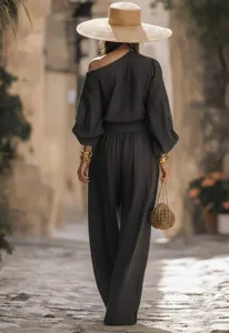 Detail shot of women's stylish off-shoulder top and wide-leg trousers set in dark grey.