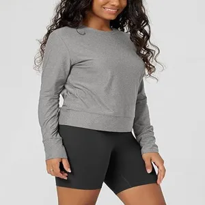 Detail view of women's solid grey long sleeve crewneck top paired with black shorts, soft knit fabric.