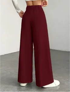 Achterkant detail van de damens hoge taille wijde ribfluwelen broek in donkerrood.