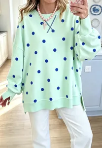 Mint green long sleeve sweatshirt detail with blue polka dots and a relaxed casual style.