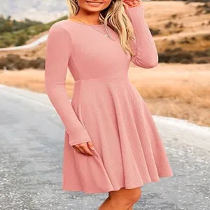 Pink long-sleeve knit midi dress close-up, featuring round neck and flared A-line silhouette.