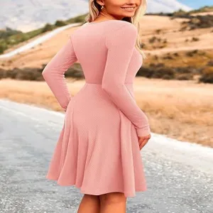 Detailed view of the pink ribbed long-sleeve crewneck dress, slim fit and elegant design.
