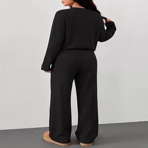 Detail view of the black two-piece lounge set with long sleeve top and wide leg pants.