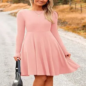 Detail view of the elegant pink long-sleeve ribbed dress worn outdoors, stylish look.