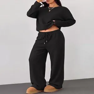 Detail view of casual black two-piece lounge set featuring long sleeves and wide leg pants.