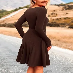 Detailed view of the solid brown ribbed long-sleeve dress worn outdoors on a clear road.