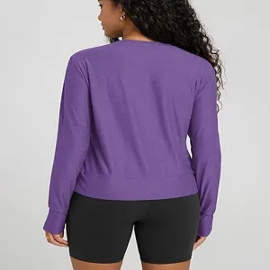 Close-up detail view of women's solid purple crewneck long sleeve top and black shorts.