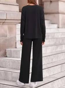 Detailed view of the black ribbed long sleeve top and wide leg pants outdoor steps.