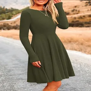 Detailed view of women's dark green long sleeve ribbed dress in a natural outdoor setting.