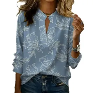 Gedetailleerd uitzicht op de stof van de blauwe bloemenprint blouse met lange mouwen.