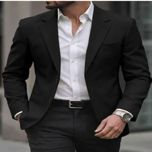 Vue de détail du costume d'affaires noir pour homme avec chemise blanche et montre.