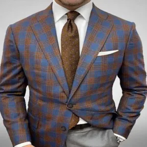 Close-up detail of stylish men's blue and brown plaid suit jacket with elegant tie and pocket square.