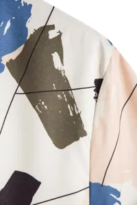 Gros plan montrant le détail de l'imprimé abstrait et géométrique de la chemise à manches courtes.