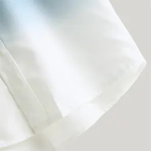 Primo piano dell'orlo della camicia da uomo sfumata, tessuto morbido e cuciture pulite.