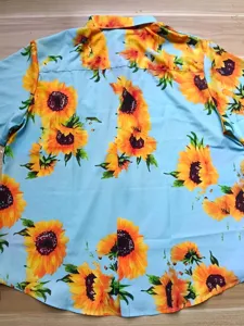 Detaillierte Nahaufnahme des lebendigen Sonnenblumen-Druckmusters auf der Rückseite des Hemdes.