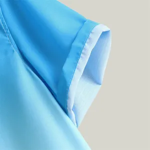 Primo piano dettagliato del polsino della camicia da uomo sfumata blu con cuciture pulite.