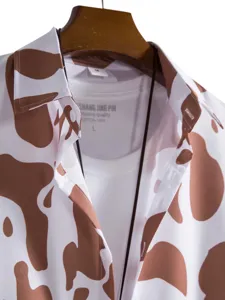 Detailed view of men's brown and white cow print short sleeve casual shirt with inner tee.