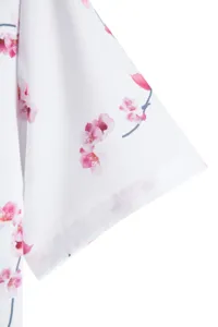 Floral print short sleeve shirt sleeve detail showing delicate cherry blossom pattern.