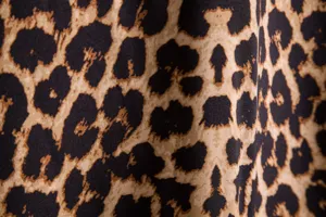 Primer plano detallado del elegante tejido con estampado de leopardo masculino y textura.
