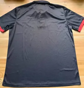 Back detail view of the casual black short-sleeve polo shirt featuring contrasting red cuffs.