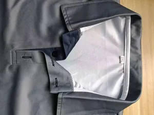 Close-up detail shot showing the collar and button placket of a grey mens polo shirt.