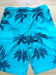Detailed view of mens tropical palm tree print casual beach shorts fabric texture.