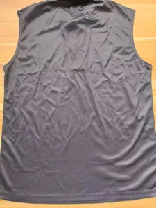 Gros plan sur la texture du tissu du polo sans manches uni, haut pour homme décontracté.