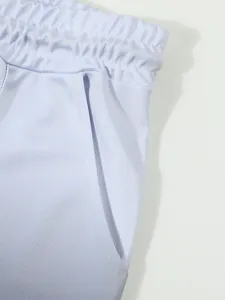 Close-up detail of men's athletic shorts featuring elastic waistband and gradient mesh fabric.