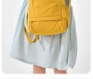 Light yellow women casual backpack with front pocket and straps for daily commute. Detail view.