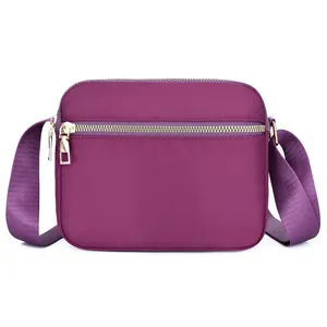 Purple nylon crossbody bag with zipper pocket and adjustable shoulder strap for daily commute.