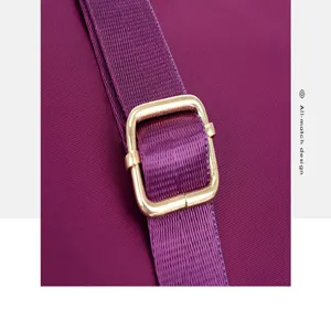 Close-up detail view of the purple nylon bag strap and gold-tone metal adjuster buckle.