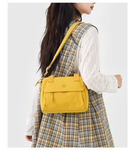 Yellow crossbody shoulder bag detail, casual daily commuter square bag worn by model.