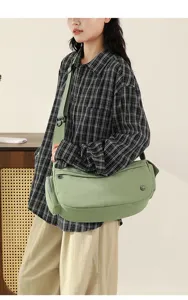 Green nylon crossbody bag detail showing shoulder strap and casual commuter style design.