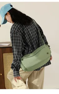 Green nylon shoulder bag detail view, showing large capacity and casual daily style.