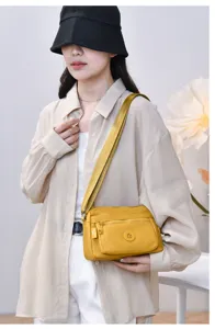 Detail view of model wearing the casual yellow nylon crossbody shoulder bag in daily life.