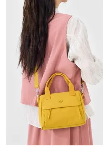 Detailed view of yellow canvas crossbody bag worn by model, showing strap and texture.