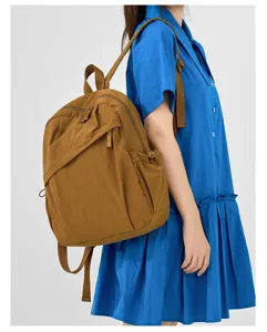 Detail view of casual unisex travel backpack, lightweight solid color daily commuting bag.