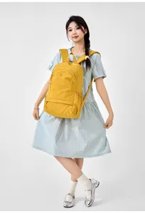 Detail shot of the yellow casual backpack worn by the model, showing front pocket and straps.