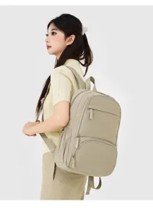 Detailed side view of a stylish casual beige backpack worn by a model, showcasing everyday design.