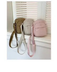 Casual mini crossbody bag detail in three colors with adjustable strap and front pocket.