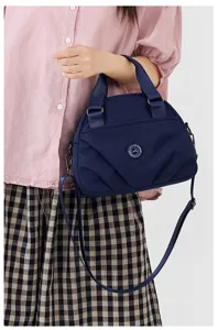 Detailed view of the dark blue nylon shoulder bag with multi-layer practical design.