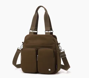 Nylon shoulder bag detail view showing multiple front pockets, sturdy handles and durable zippers.