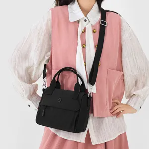 Black canvas crossbody bag for women, casual tote with adjustable strap and front pocket.